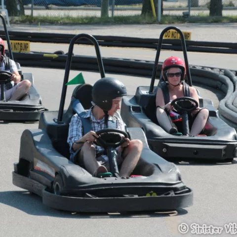 three people racing in gocarts