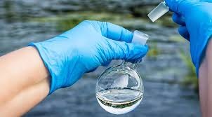 Water quality testing photo of a surgical gloved hand testing water