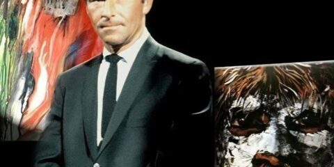photo of Rod Serling standing in front of Night Gallery paintings